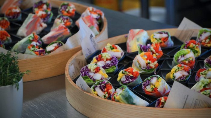 Spalvingi summer rolls su krevetėmis, šviežiomis daržovėmis ir žalumynais, patiekti užkandžių padėkluose – maistas šventėms ir renginiams.